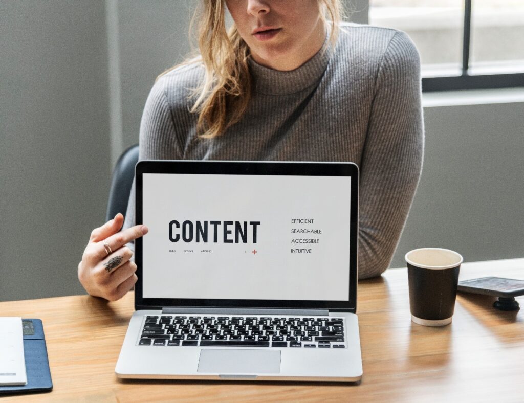 Content outsourcing https://www.freepik.com/free-photo/blond-woman-pointing-laptop-screen_11303555.htm#fromView=search&page=1&position=5&uuid=0e570b18-68e8-41f0-9b95-e19ac3b85b93&query=content Image of a laptop that says content on it and a woman pointing to it. 